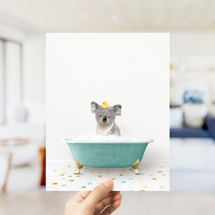 A small gray dog is sitting in a green bathtub filled with bubbles, wearing a yellow rubber duck hat.