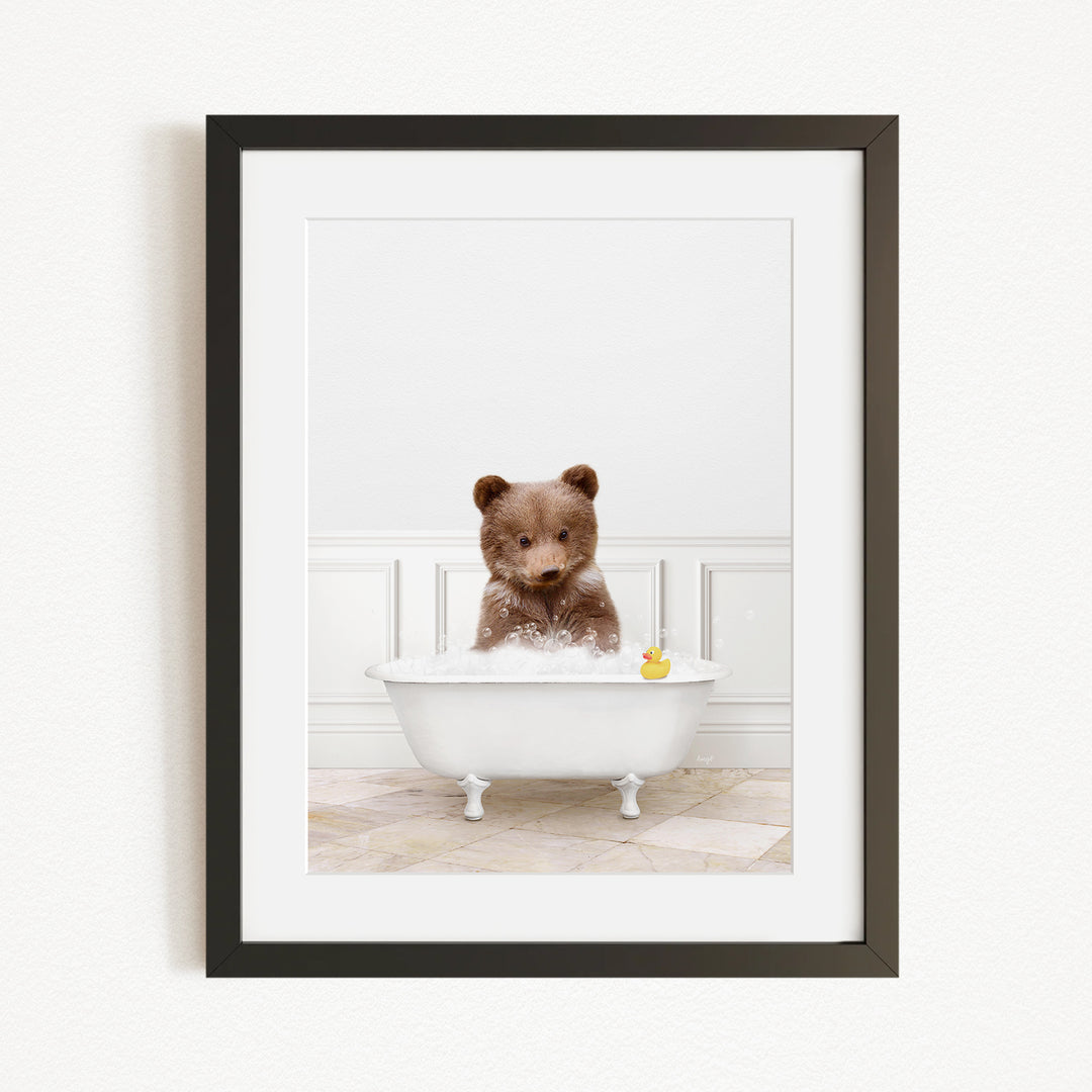 A brown bear sitting in a white bathtub, with a yellow rubber duck floating in the water.