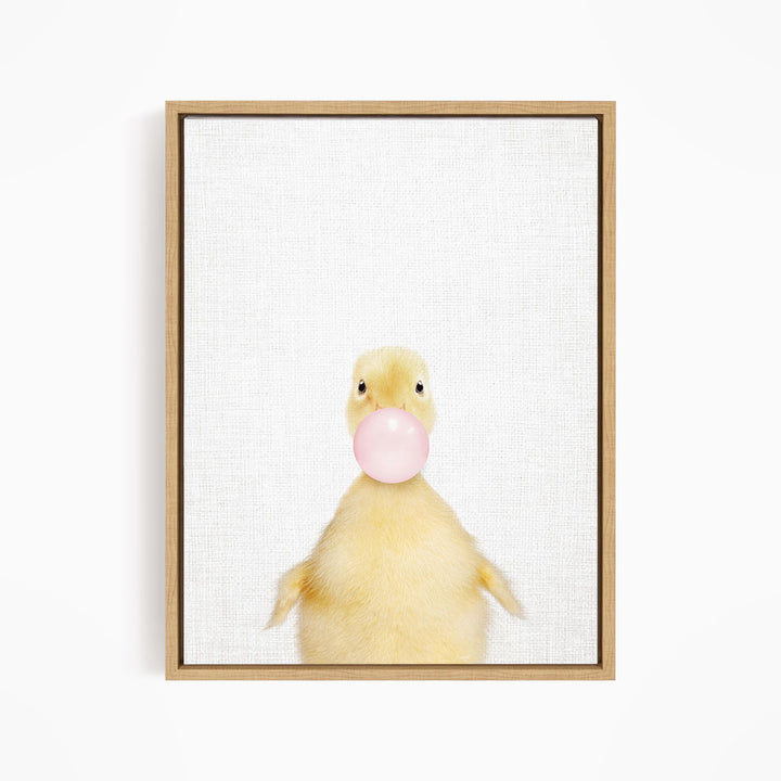 A cute yellow duck blowing a bubble with a pink bubble gum bubble.