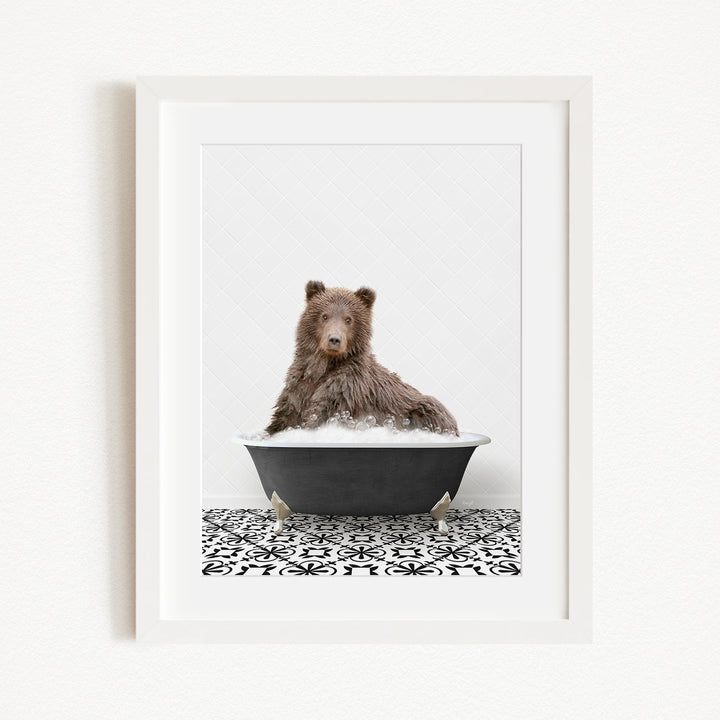 A brown bear sitting in a black bathtub filled with water, surrounded by a black and white patterned floor.