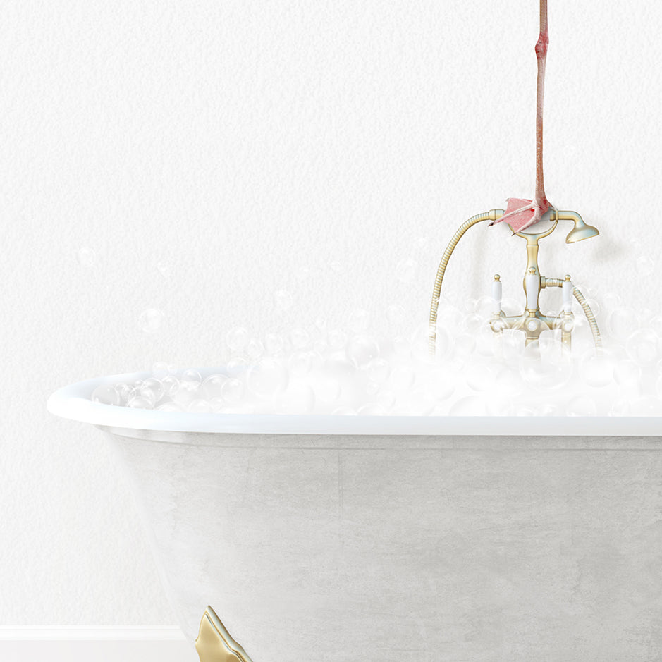 a white bath tub with a pink flower on the faucet