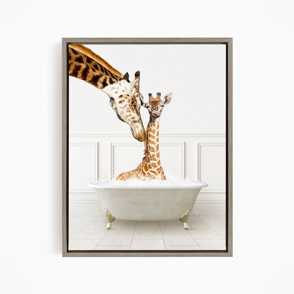 A mother giraffe and her baby giraffe are sitting together in a white bathtub, with the mother gently licking her baby.