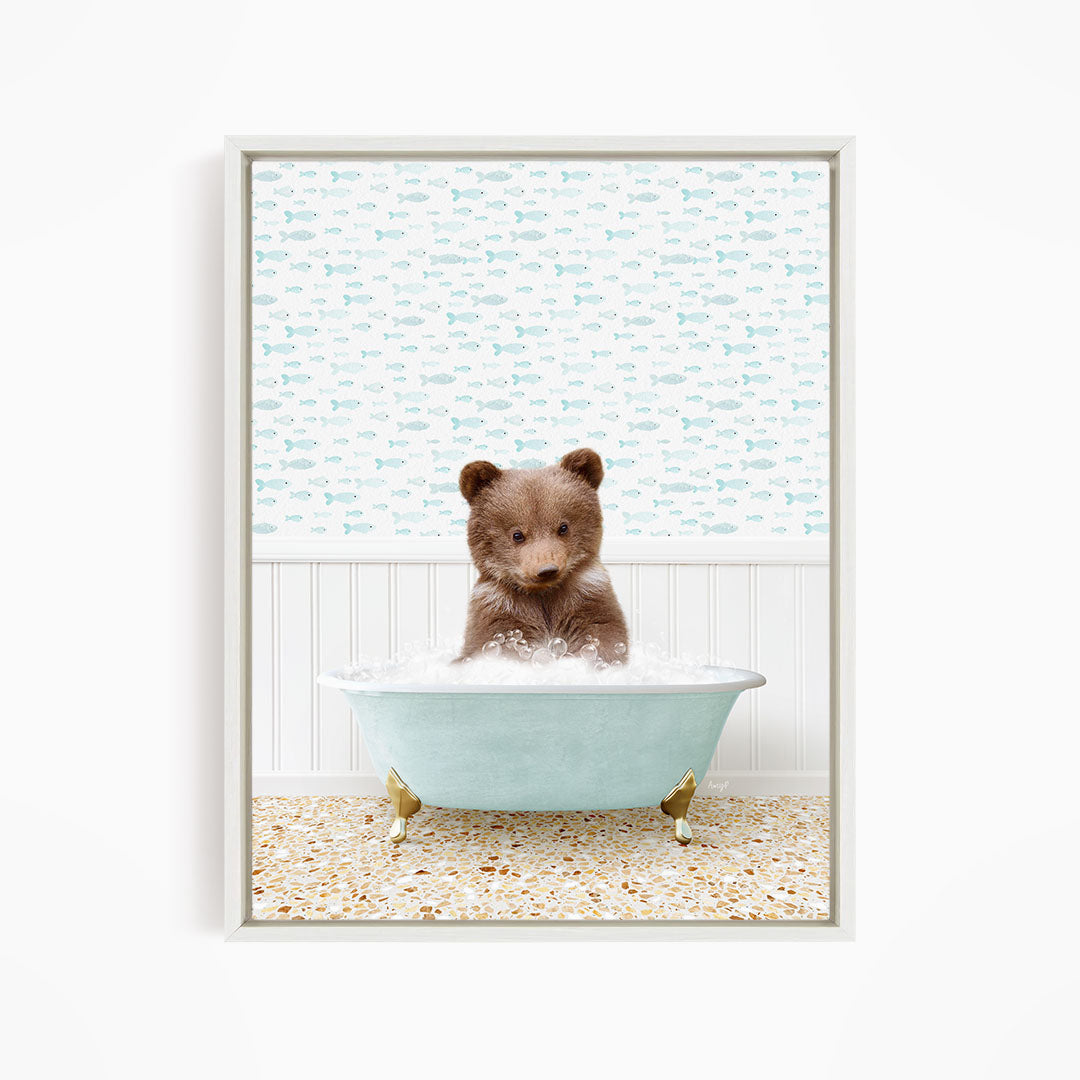 A cute brown bear sitting in a light blue bathtub filled with bubbles, surrounded by a pattern of small fish.