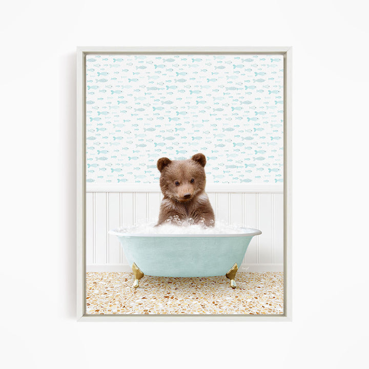 A cute brown bear sitting in a light blue bathtub filled with bubbles, surrounded by a pattern of small fish.