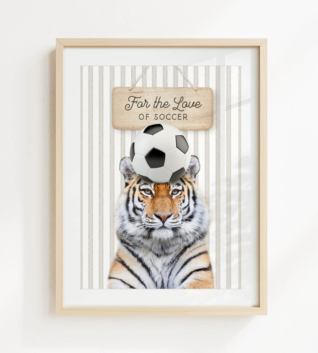 A framed image of a tiger with a soccer ball on its head, accompanied by a wooden sign that says "For the Love of Soccer".