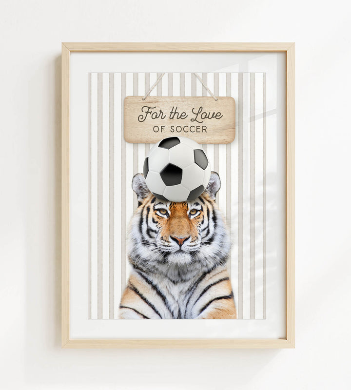 A framed image of a tiger with a soccer ball on its head, accompanied by a wooden sign that says "For the Love of Soccer".