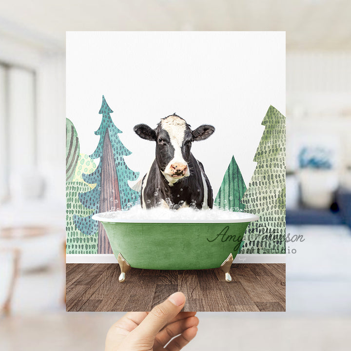 a hand holding up a card with a picture of a cow in a bathtub