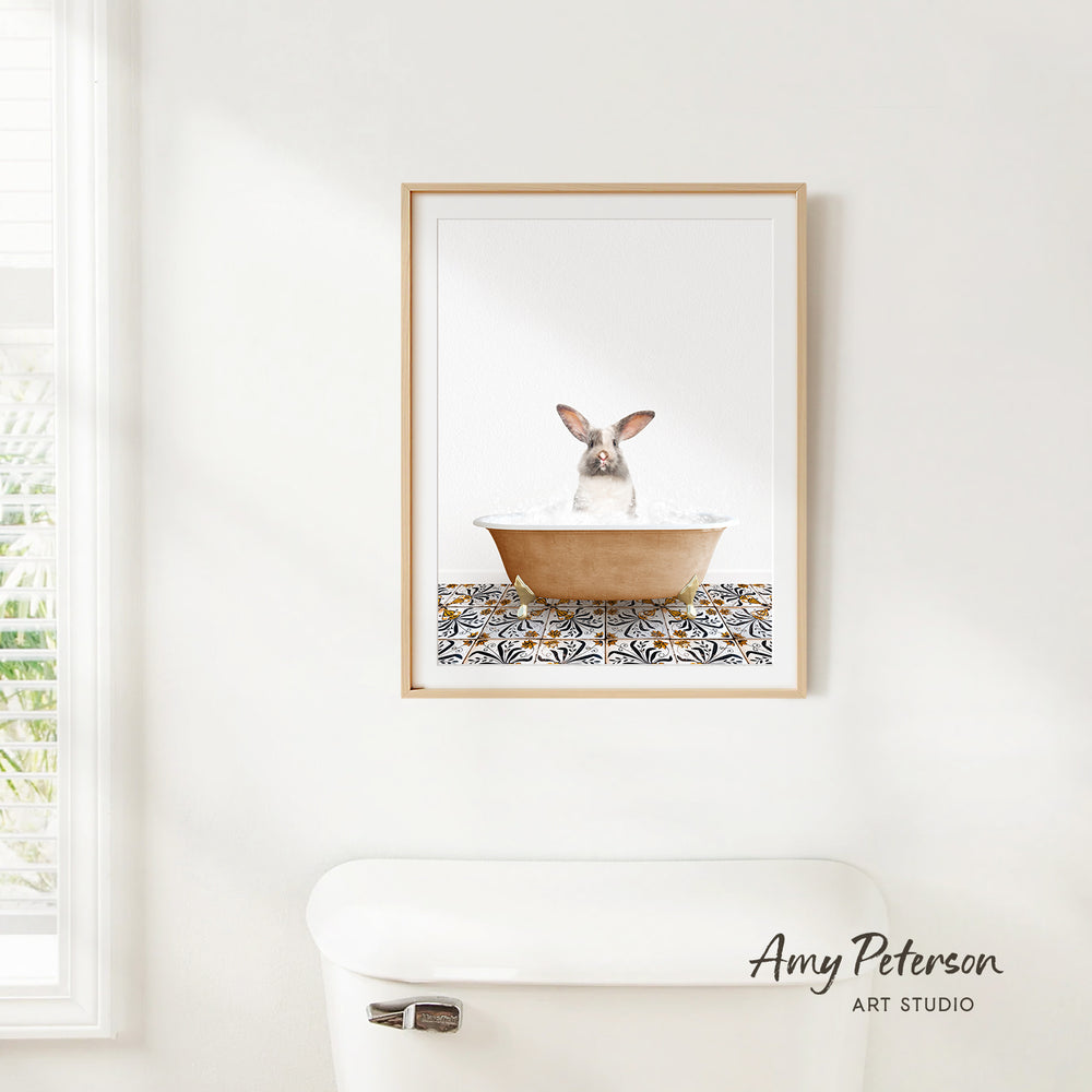A framed image of a rabbit sitting in a bathtub, with a patterned tile on the floor.