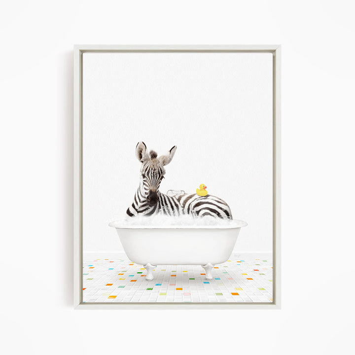 A zebra is sitting in a white bathtub, surrounded by a yellow rubber duck and a yellow rubber ducky.