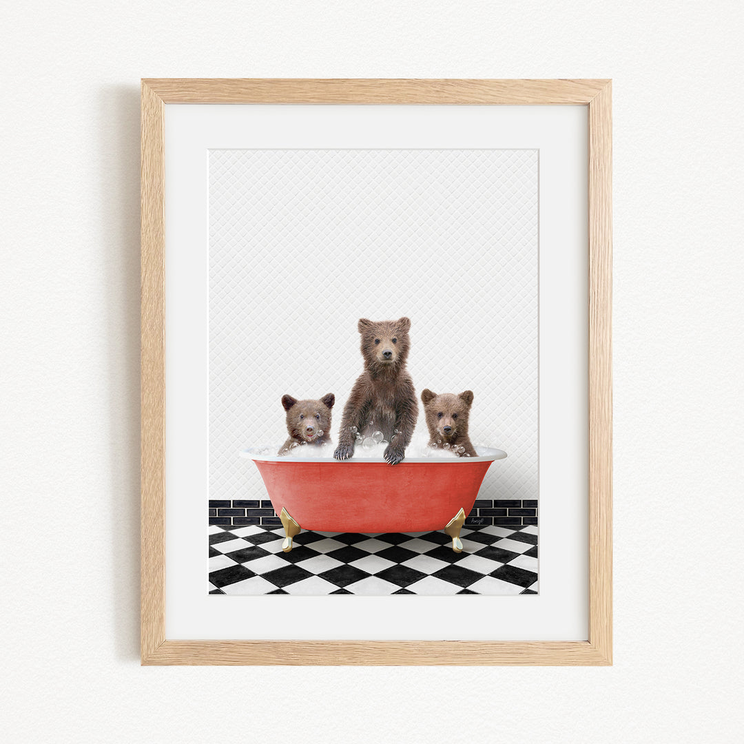 A framed image depicting three bears sitting in a red bathtub on a black and white checkered floor.
