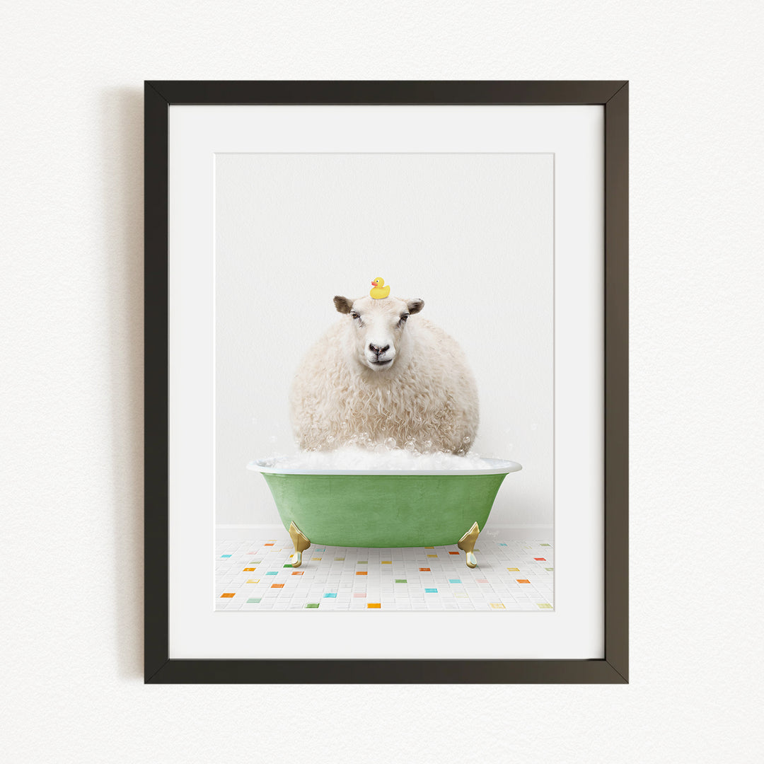 A fluffy white sheep sits in a green bathtub filled with bubbles, with a yellow rubber duck perched on its head.
