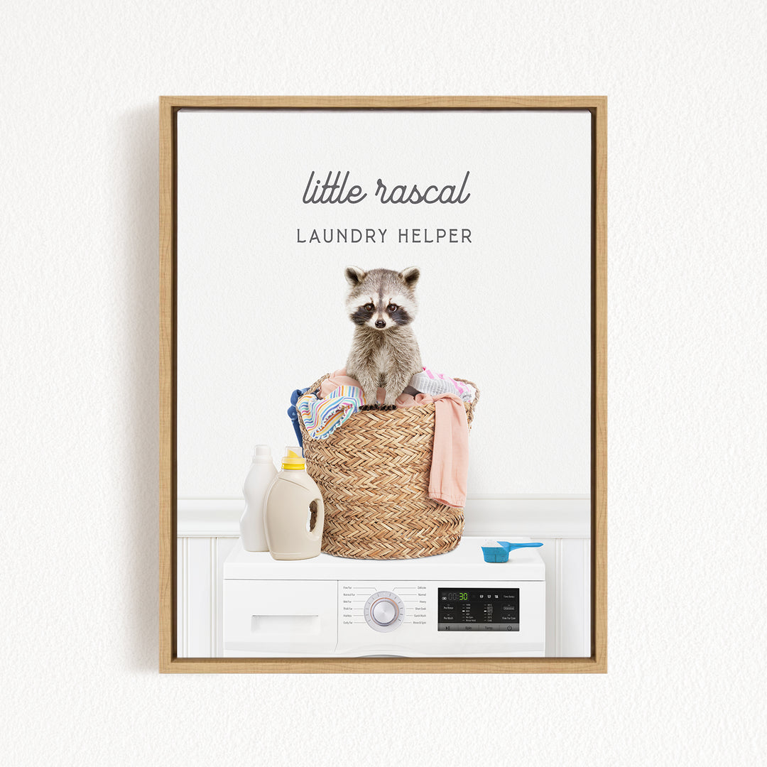 A raccoon sitting in a laundry basket filled with clothes and laundry supplies, with a washing machine and detergent bottle nearby.