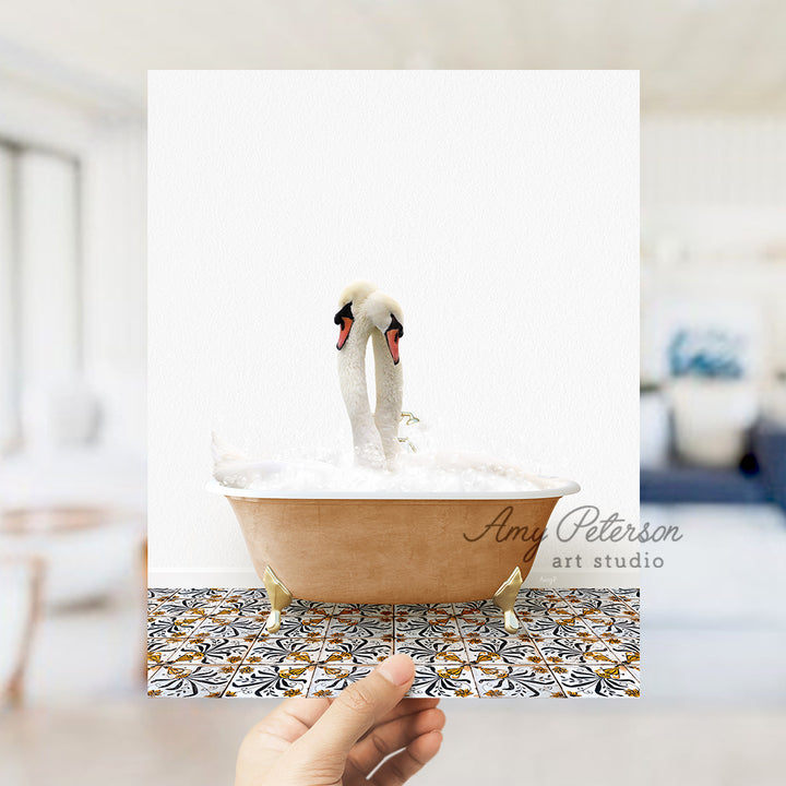 a person holding a card with two swans in a bathtub