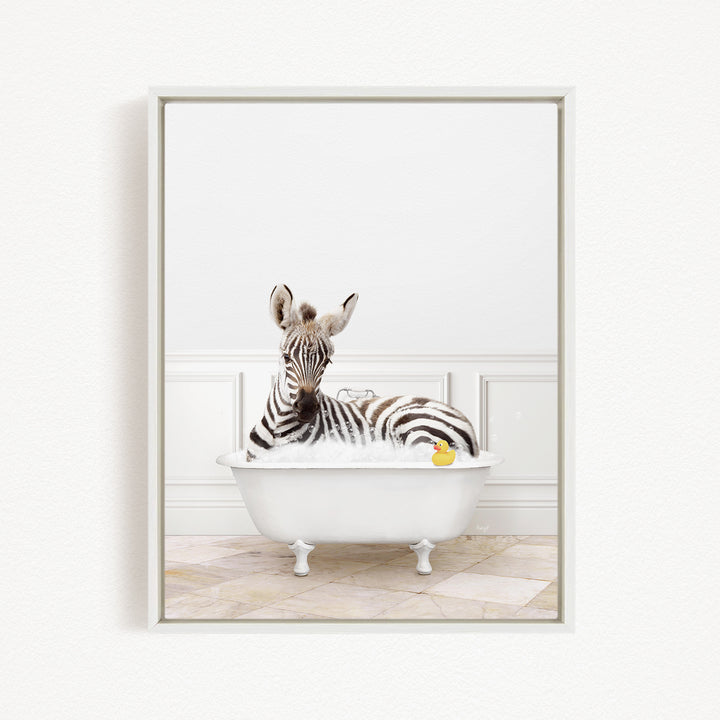 A zebra is sitting in a white bathtub filled with water, surrounded by a yellow rubber duck.