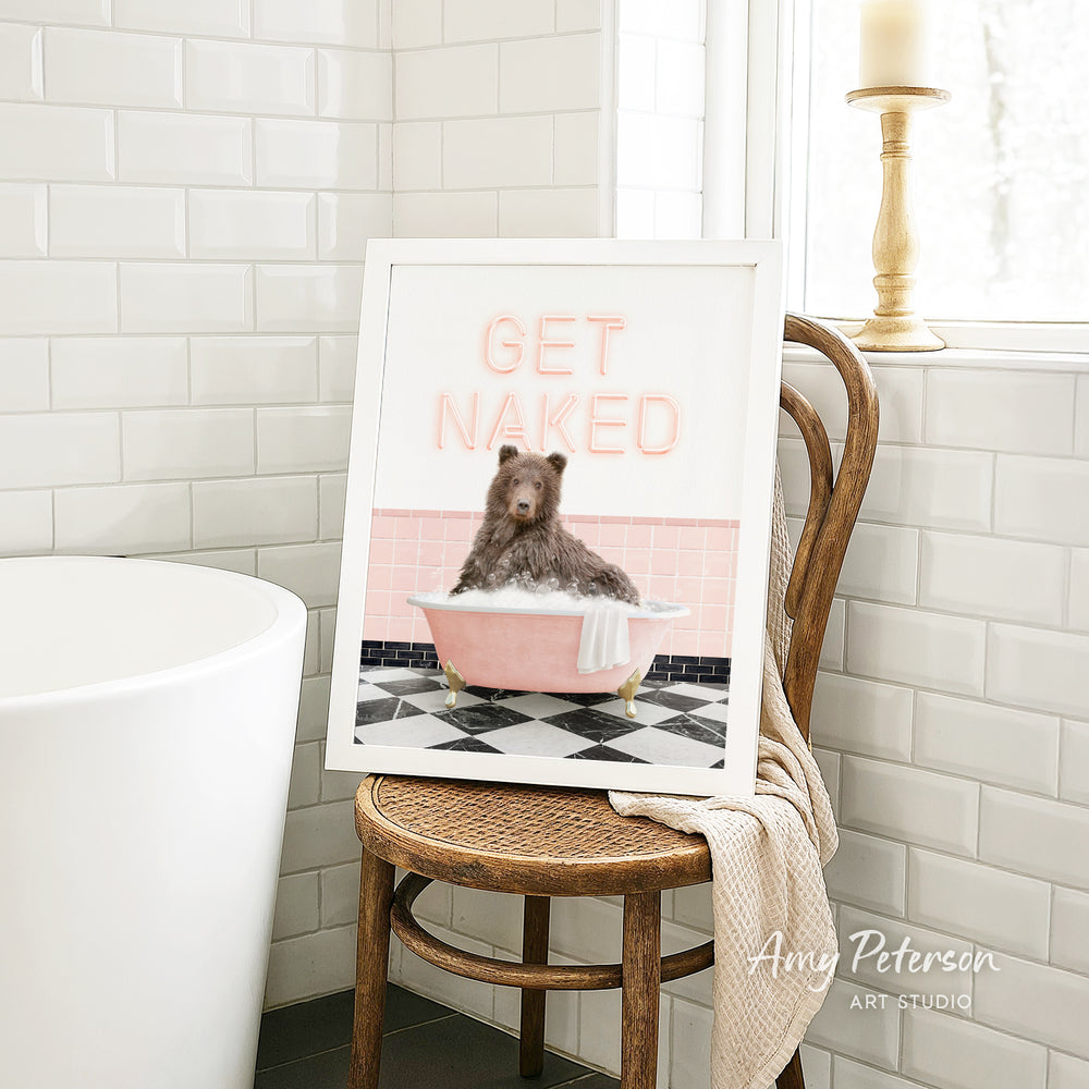A framed image of a bear sitting in a pink bathtub, with the text "GET NAKED" displayed on the frame.