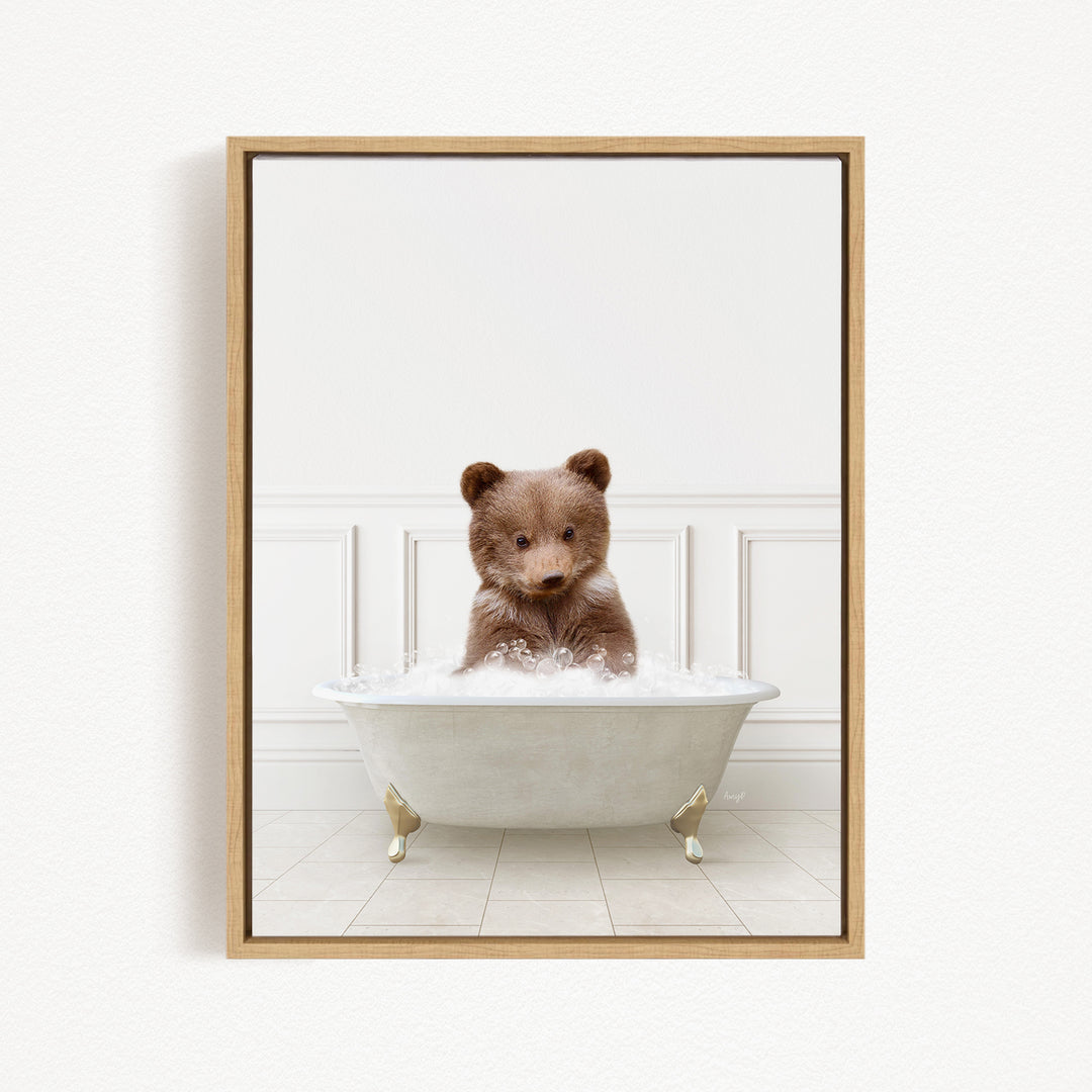A brown bear sitting in a white bathtub filled with bubbles, looking directly at the camera.
