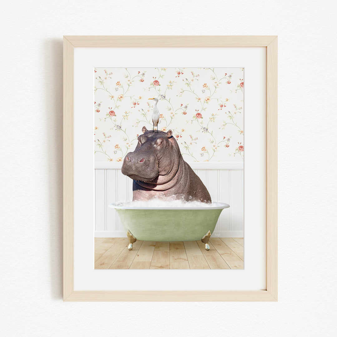 A framed image depicting a hippopotamus sitting in a bathtub filled with water, with a bird perched on its head.