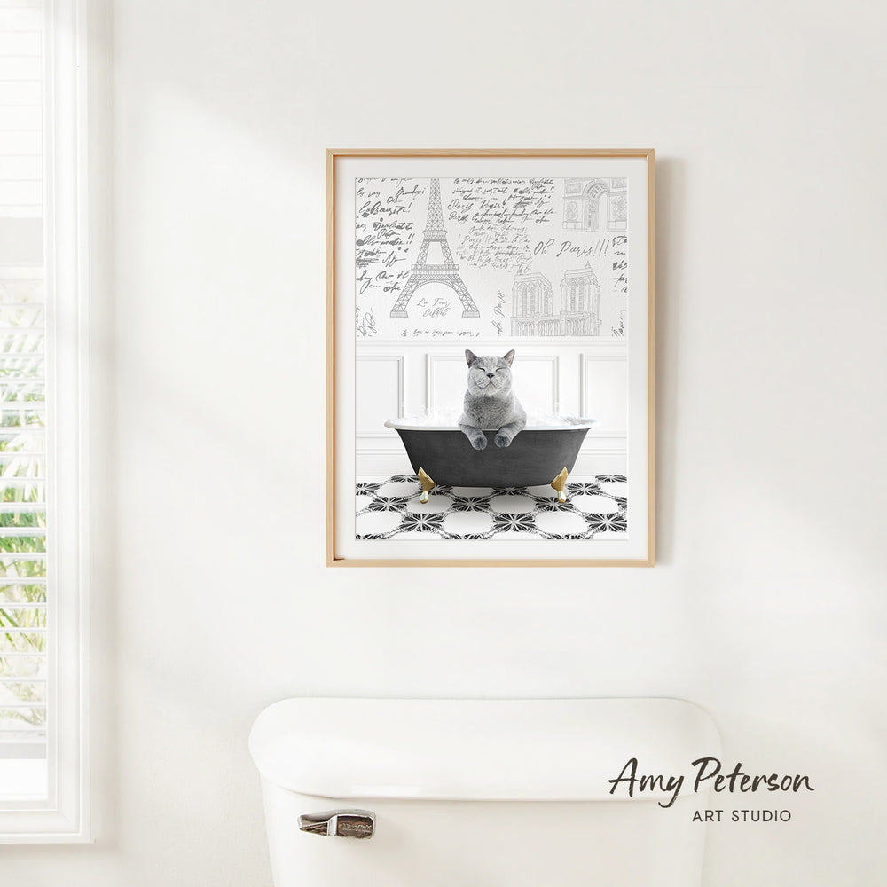 A framed photograph of a cat sitting in a bathtub, with various architectural drawings and text visible in the background.