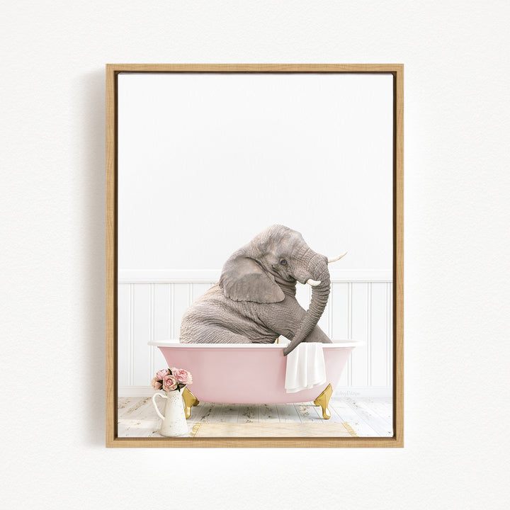 A gray elephant sitting in a pink bathtub, with a vase of flowers and a white towel nearby.