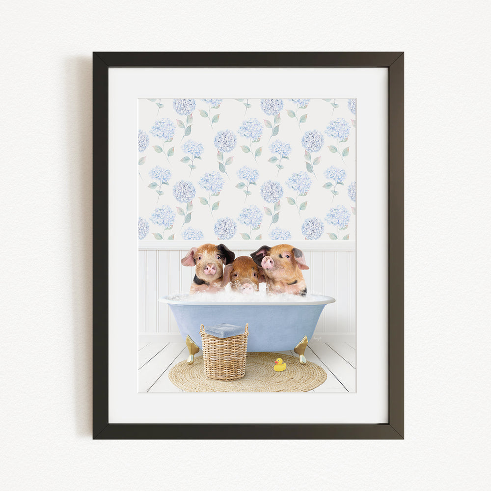 Three adorable pigs sitting in a blue bathtub, surrounded by a floral patterned wall and a basket of rubber ducks.