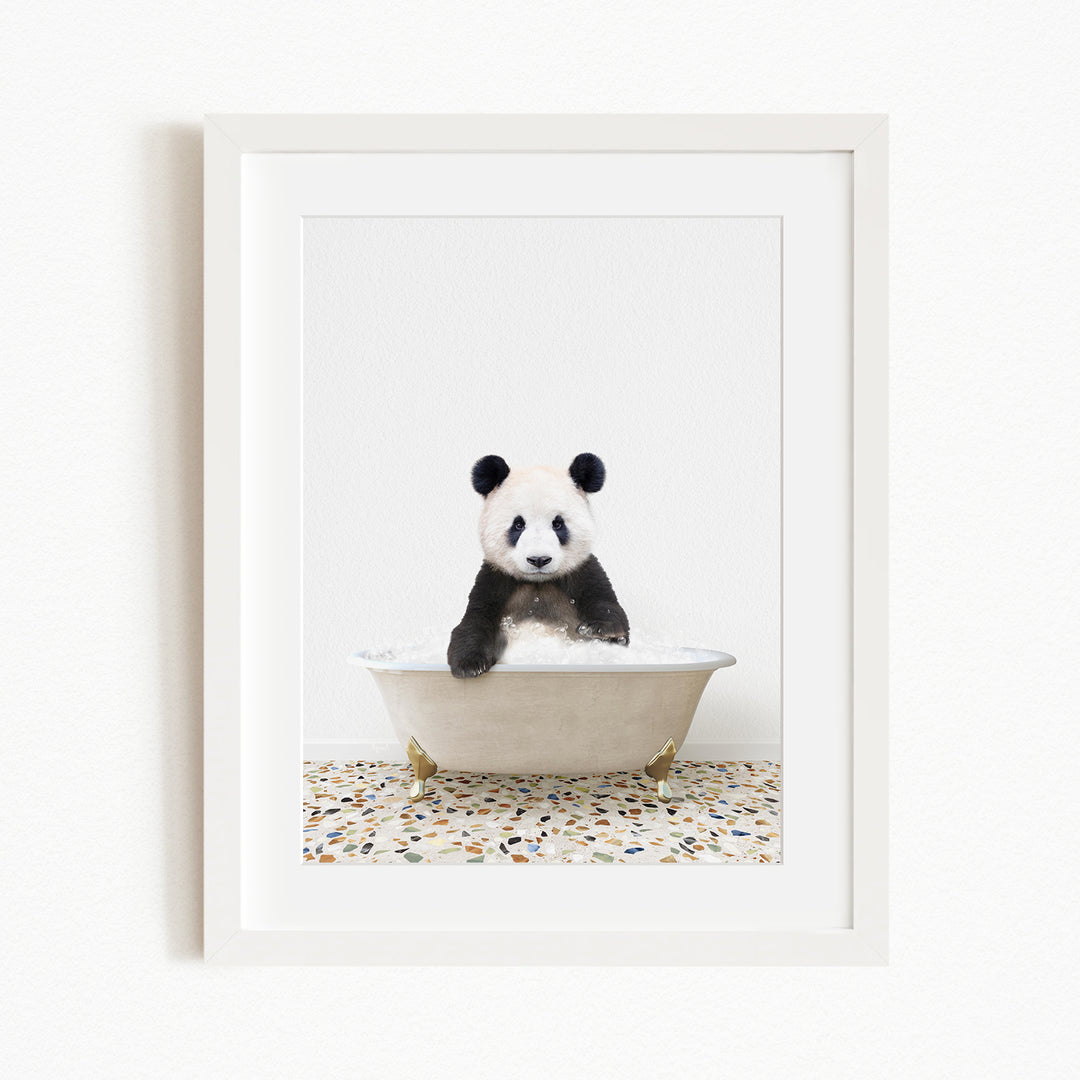 A panda bear sitting in a white bathtub filled with water, surrounded by a tiled floor.