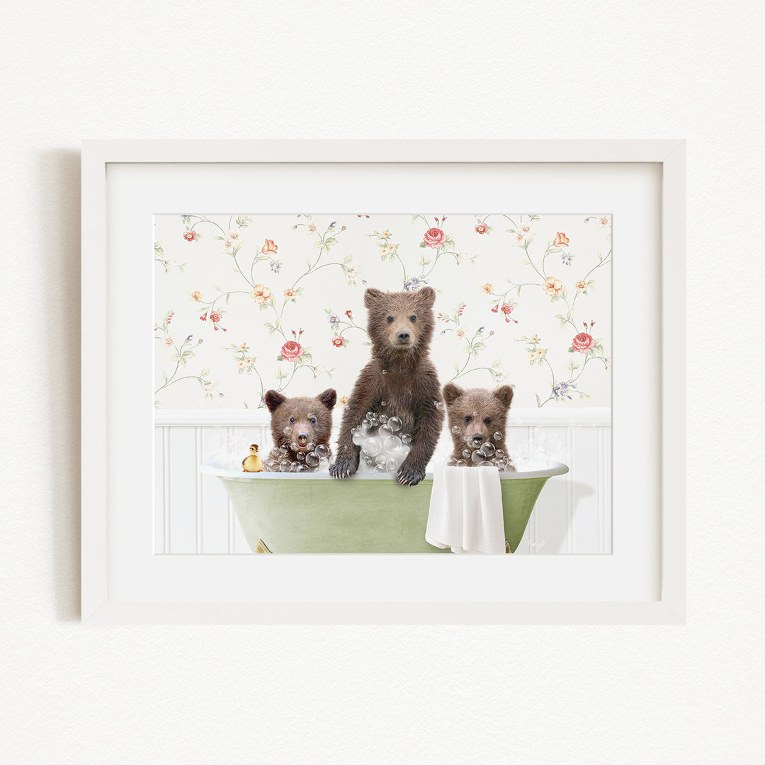 A framed image depicting three bears sitting in a green bathtub, with one bear standing on the edge of the tub and the other two bears sitting inside the tub.