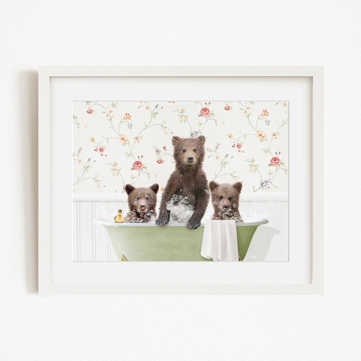 A framed image depicting three bears sitting in a green bathtub, with one bear standing on the edge of the tub and the other two bears sitting inside the tub.