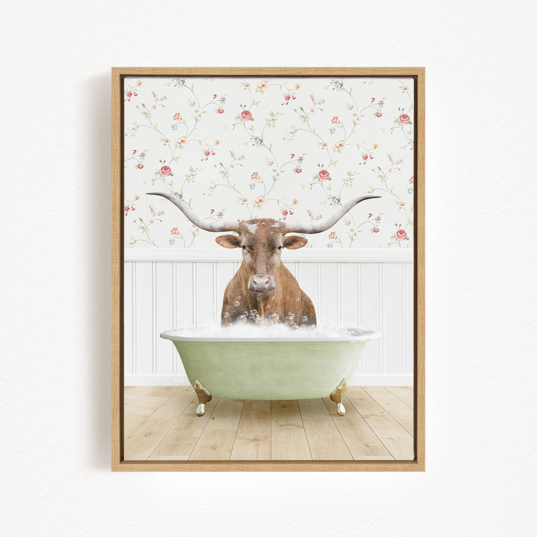 A brown cow with large horns is sitting in a green bathtub filled with water, surrounded by a floral wallpaper.